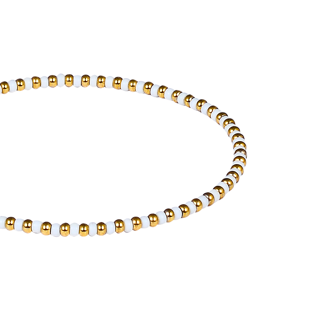 Bracelet with gold and white beads on a white background