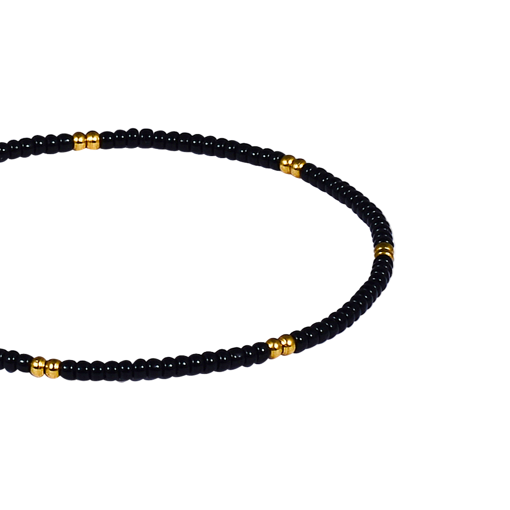 Black beaded bracelet with gold accents on a white background
