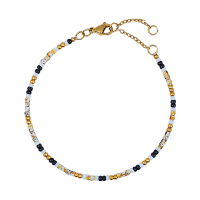 Beaded bracelet with gold, black, and white beads on a white background