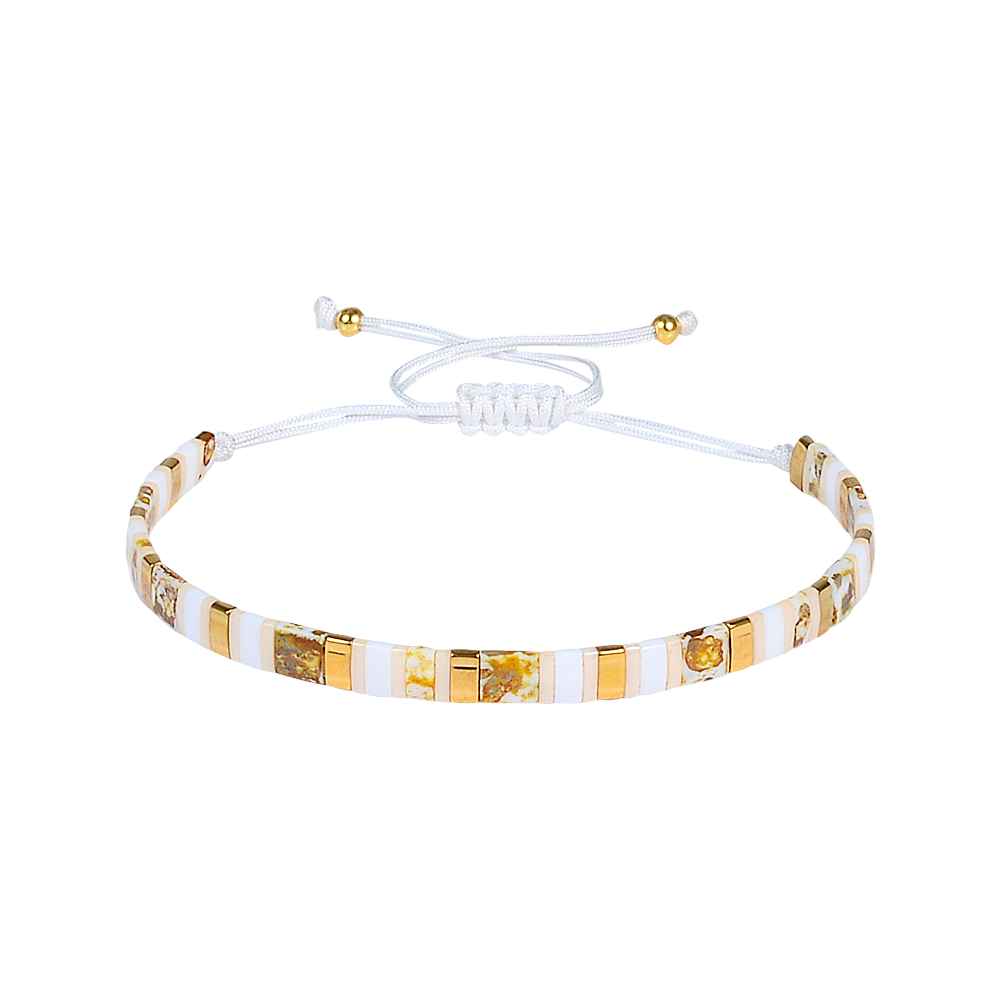 Bracelet with gold and white beads on a white background